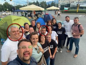 На тази прекрасна снимка виждате депутата от ПП, а преди това кандидат на Мая Манолова – Настимир Ананиев, в чудна компания. Точно зад него на фотото е Ицо Турчина (всъщност представител на друго малцинство), виден автоджамбазин, последните арести на когото от септември 2017 г., февруари 2018 г. и 4 юни 2021 г. Другият мъж на предни позиции на снимката, когото сме обозначили, е също криминално проявен – задържаният за търговия със стоки – менте Тихомир Василев